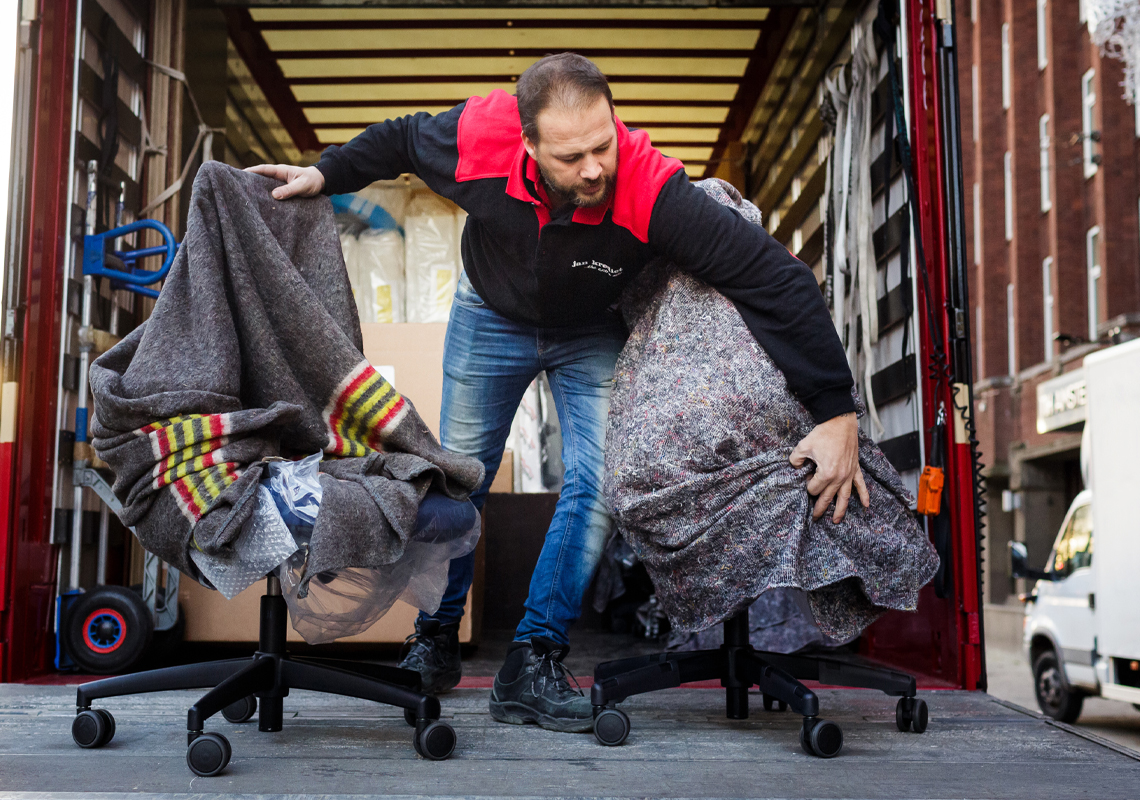 Man laadt bureaustoelen uit - Meubellogistiek - Jan Krediet