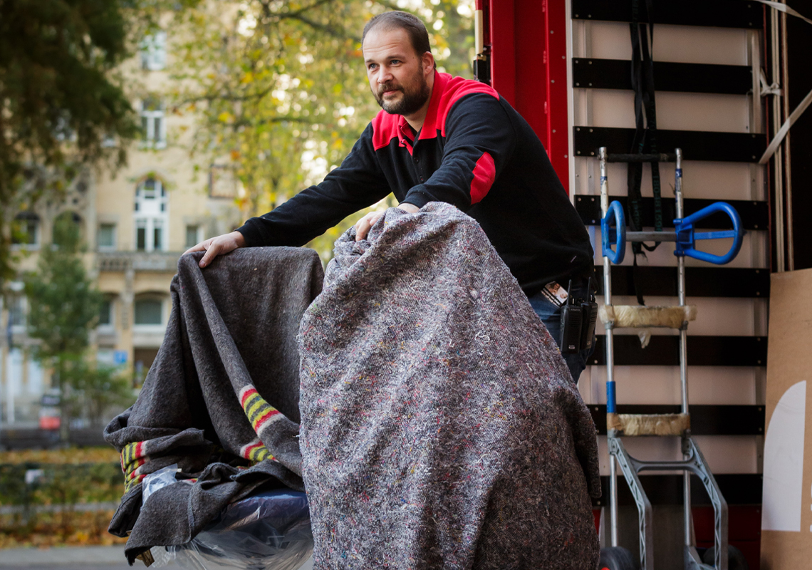 Man laadt bureaustoelen uit vrachtwagen - Meubellogistieke oplossingen - Jan Krediet