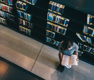 Vrouw leest boek in bibliotheek - Logistieke oplossingen publieke sector - Jan Krediet