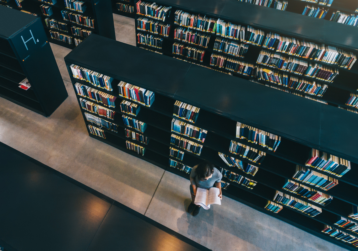 Vrouw leest boek in bibliotheek - Logistieke oplossingen publieke sector - Jan Krediet